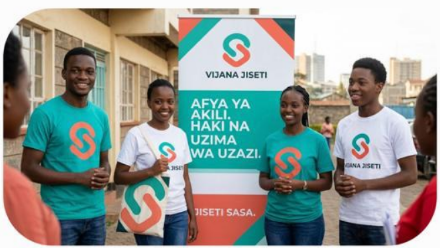 Vijana Jiseti youth members in branded t-shirts standing beside a Vijana Jiseti banner in Nyamira